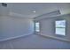 Bright bedroom features two windows, neutral carpet, and a tray ceiling at 4938 Vue Delac Pass, Auburndale, FL 33823