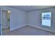 Bedroom with neutral carpet, one window, and view into bathroom at 4938 Vue Delac Pass, Auburndale, FL 33823