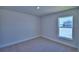 Cozy bedroom featuring neutral carpet, bright natural light, and view of neighborhood at 4938 Vue Delac Pass, Auburndale, FL 33823
