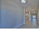 Bright hallway featuring tile floors and a view into the kitchen and dining area at 4938 Vue Delac Pass, Auburndale, FL 33823
