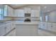Bright kitchen featuring white cabinets, granite countertops, and an island with pendant lighting at 4938 Vue Delac Pass, Auburndale, FL 33823