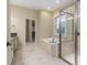 Bathroom with tiled floors, walk-in closet, soaking tub, and a glass-enclosed shower at 8288 Lake James Dr, Lakeland, FL 33810