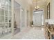 Bright and airy foyer with tile flooring, a chandelier, and a view of the front door, creating an open and welcoming space at 8288 Lake James Dr, Lakeland, FL 33810