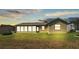 Home's backyard featuring green grass and a screened-in sunroom addition at 5879 Swallow Dr, Lakeland, FL 33809