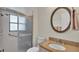 Bathroom with a shower, a round mirror, and decorative sconces at 5879 Swallow Dr, Lakeland, FL 33809