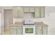 The kitchen showcases light green cabinets, white appliances, and ample counter space at 5879 Swallow Dr, Lakeland, FL 33809