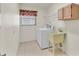 Bright laundry room with washer, dryer, utility sink, and tile flooring at 5879 Swallow Dr, Lakeland, FL 33809