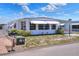 Mobile home with awning, landscaping, and mailbox at 6734 Kensington Ne Dr, Winter Haven, FL 33881