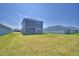 A home's backyard features an expansive lawn and a two-story house with gray siding at 4676 Grandview Glen Dr, Auburndale, FL 33823