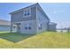 A two-story home with gray siding features a covered patio and is surrounded by a green lawn at 4676 Grandview Glen Dr, Auburndale, FL 33823
