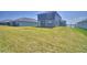 Backyard view featuring a well-maintained lawn and the rear of a two-story home with grey siding at 4676 Grandview Glen Dr, Auburndale, FL 33823
