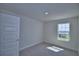 A bedroom with a neutral color scheme, carpeted floors, a window, and a white paneled door at 4676 Grandview Glen Dr, Auburndale, FL 33823