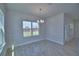 This dining room features a modern chandelier and large windows that allow ample natural light at 4676 Grandview Glen Dr, Auburndale, FL 33823