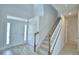 This home's foyer features a carpeted staircase, white banister, and a tile floor at 4676 Grandview Glen Dr, Auburndale, FL 33823
