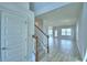 The foyer has a carpeted staircase, white banister, and a tile floor with neutral colored walls at 4676 Grandview Glen Dr, Auburndale, FL 33823