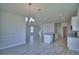 Open living space features tile floors, kitchen island, and elegant chandelier for modern living at 4676 Grandview Glen Dr, Auburndale, FL 33823