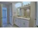 Bathroom featuring double sinks with granite counters, a large mirror and tile flooring at 4687 Grandview Glen Dr, Auburndale, FL 33823