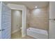 Bathroom featuring tile flooring, bathtub with tile surround, and an open doorway to the toilet at 4687 Grandview Glen Dr, Auburndale, FL 33823