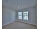 Bright bedroom featuring neutral carpet, white walls and trim, and two large double-hung windows at 4687 Grandview Glen Dr, Auburndale, FL 33823