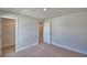 Bedroom featuring neutral carpet, white trim, paneled doors and an open closet with wire shelving at 4687 Grandview Glen Dr, Auburndale, FL 33823