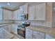 Bright kitchen features white cabinetry, stainless steel appliances, and granite countertops at 4687 Grandview Glen Dr, Auburndale, FL 33823