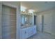 Modern bathroom with double sinks, granite countertops, and a view of the walk-in closet at 5280 Tennessee Ridge Ct, Auburndale, FL 33823