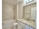 Stylish bathroom with a tub and shower combo, granite counters, and modern fixtures at 5280 Tennessee Ridge Ct, Auburndale, FL 33823