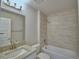 Bright bathroom with a tub and tiled shower, granite countertop, and modern fixtures at 5280 Tennessee Ridge Ct, Auburndale, FL 33823
