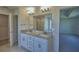 Modern bathroom with double sinks, granite countertops, and a view of the shower and bedroom at 5280 Tennessee Ridge Ct, Auburndale, FL 33823