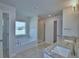 Modern bathroom featuring a separate tub and shower, with double sinks and granite countertops at 5280 Tennessee Ridge Ct, Auburndale, FL 33823
