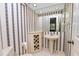 Small half bathroom with pedestal sink and striped wallpaper at 1144 Waterfall Ln # 26, Lakeland, FL 33803