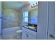 Bathroom with tiled shower and bathtub, modern fixtures, and natural light from window at 5120 Villa Crest Way, Auburndale, FL 33823