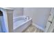 Inviting bathroom featuring a soaking tub with bronze fixtures and tile flooring at 5120 Villa Crest Way, Auburndale, FL 33823