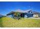 Beautifully landscaped single-story home with a blue exterior and manicured lawn on a sunny day at 5120 Villa Crest Way, Auburndale, FL 33823