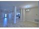 Spacious living room with wood-look tile, stylish chandelier, and an open concept design leading to the kitchen at 5120 Villa Crest Way, Auburndale, FL 33823