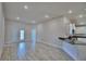 Bright and airy living room with wood-look tile, recessed lighting, and an open layout leading to the kitchen at 5120 Villa Crest Way, Auburndale, FL 33823