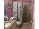 Bright bathroom featuring granite vanity top, tiled shower, and colorful shower curtain at 2875 Creeks Crossing Blvd, Lakeland, FL 33810