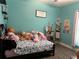 Comfortable bedroom with blue walls, vinyl wood floors, and lots of stuffed animals at 2875 Creeks Crossing Blvd, Lakeland, FL 33810