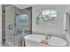 Bathroom features a glass shower and soaking tub next to a window at 7365 Millbrook Oaks Dr, Lakeland, FL 33813