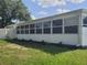 Bright sunroom featuring a wall of windows and a crisp white exterior, complemented by a well-maintained lawn at 152 Audubon Ct, Winter Haven, FL 33884