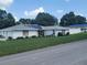 Well-kept single-story home featuring white brick, solar panels, lush lawn, and an adjacent fenced yard for privacy at 152 Audubon Ct, Winter Haven, FL 33884