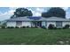 Charming single-story home featuring a white brick exterior, solar panels, well-maintained landscaping and inviting front porch at 152 Audubon Ct, Winter Haven, FL 33884