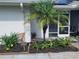 Charming entrance adorned with a variety of plants, flowers, and palm tree, enhancing the home's curb appeal at 152 Audubon Ct, Winter Haven, FL 33884