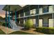 Exterior view of condo building featuring stairwell, covered walkways, and lush landscaping at 1600 W Lake Parker Dr # A2, Lakeland, FL 33805