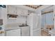 Efficient kitchen with white cabinets and appliances, plus a view of the dining area at 1600 W Lake Parker Dr # A2, Lakeland, FL 33805