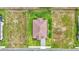 An aerial perspective shows the home's roof, landscaping, and surrounding property with adjacent neighbors at 574 Loblolly Pl, Auburndale, FL 33823