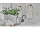Bathroom vanity featuring decorative flowers, soap dispenser and towels, with a well-lit mirror above the sink at 574 Loblolly Pl, Auburndale, FL 33823