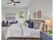 Light and airy bedroom featuring a large bed, artwork, and two chairs with modern ceiling fan at 574 Loblolly Pl, Auburndale, FL 33823