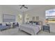 Bright bedroom featuring modern furniture, large windows, and neutral decor with a ceiling fan at 574 Loblolly Pl, Auburndale, FL 33823