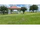 A gazebo on a grassy area offers a peaceful retreat with a serene lake view in the background at 574 Loblolly Pl, Auburndale, FL 33823